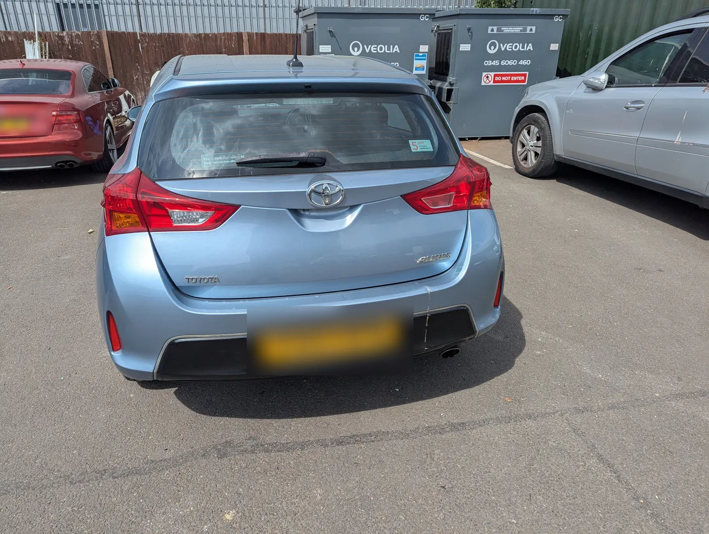 Before: Blue Toyota Auris with scuffs and scrapes along the lower rear bumper