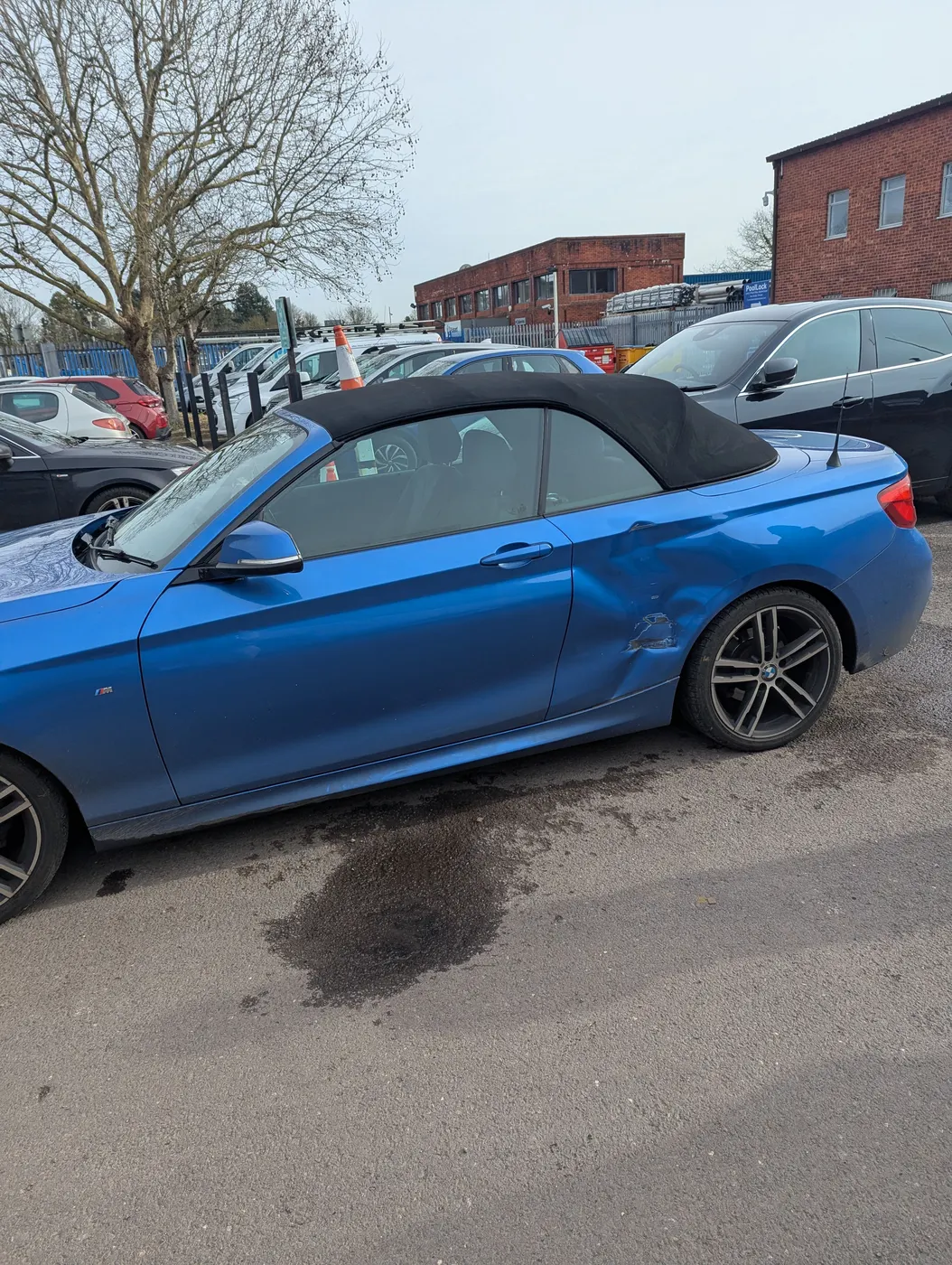 Before: Blue BMW 2 Series Convertible with a dent in the rear wing behind the door
