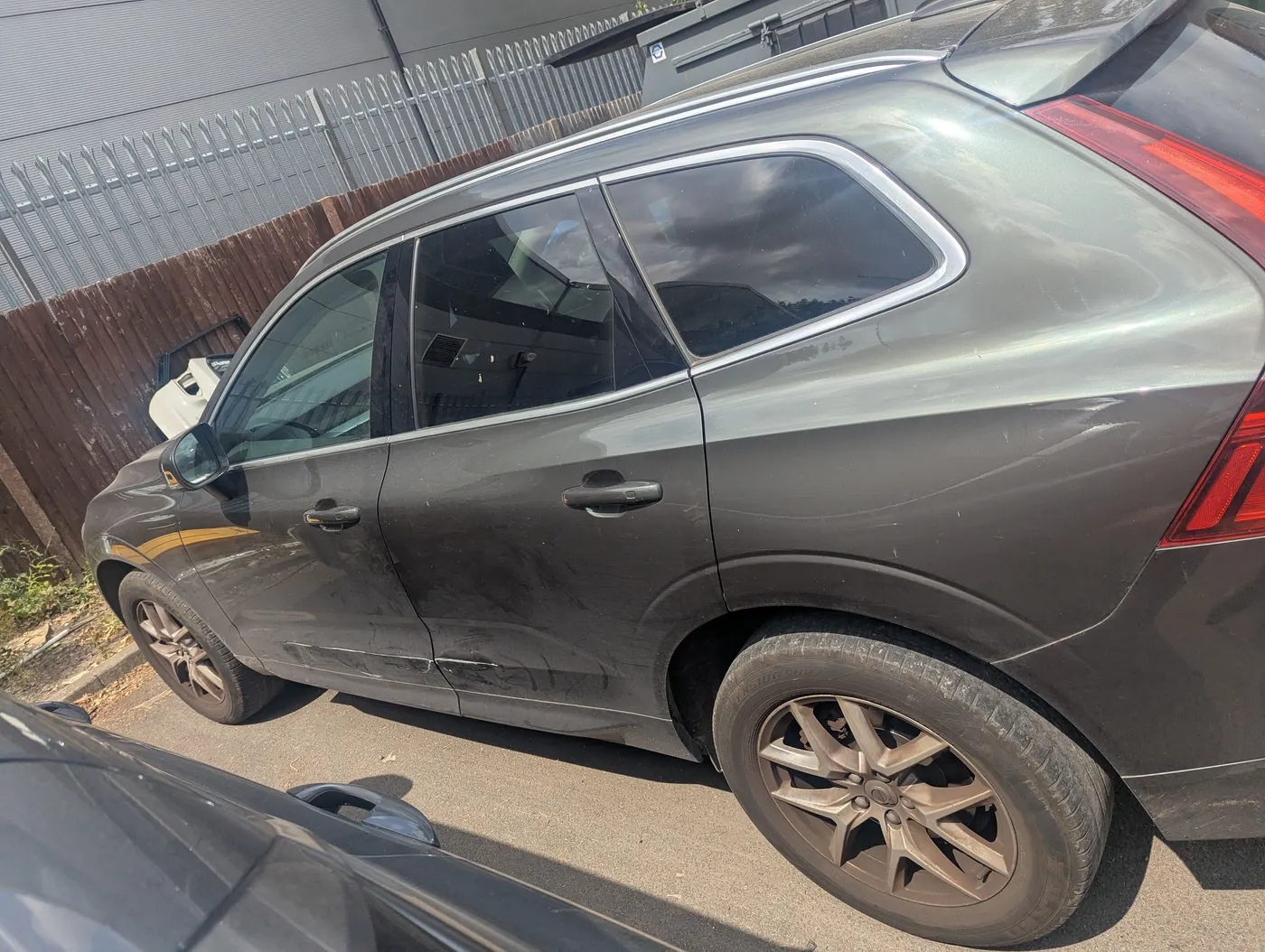 Before: Grey Volvo XC60 with scrapes and dents along the rear door and wheel arch